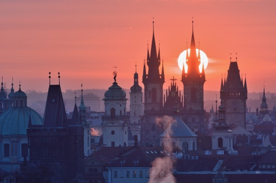 Praha, východ slunce nad pražskými věžemi